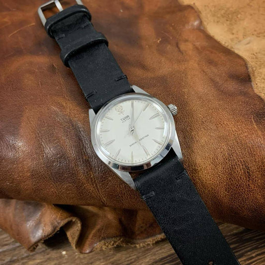 Vintage Nero strap adorning a classic Tudor Oyster: Capture the timeless elegance of the pairing, highlighting how the strap's vintage charm complements the watch's iconic design